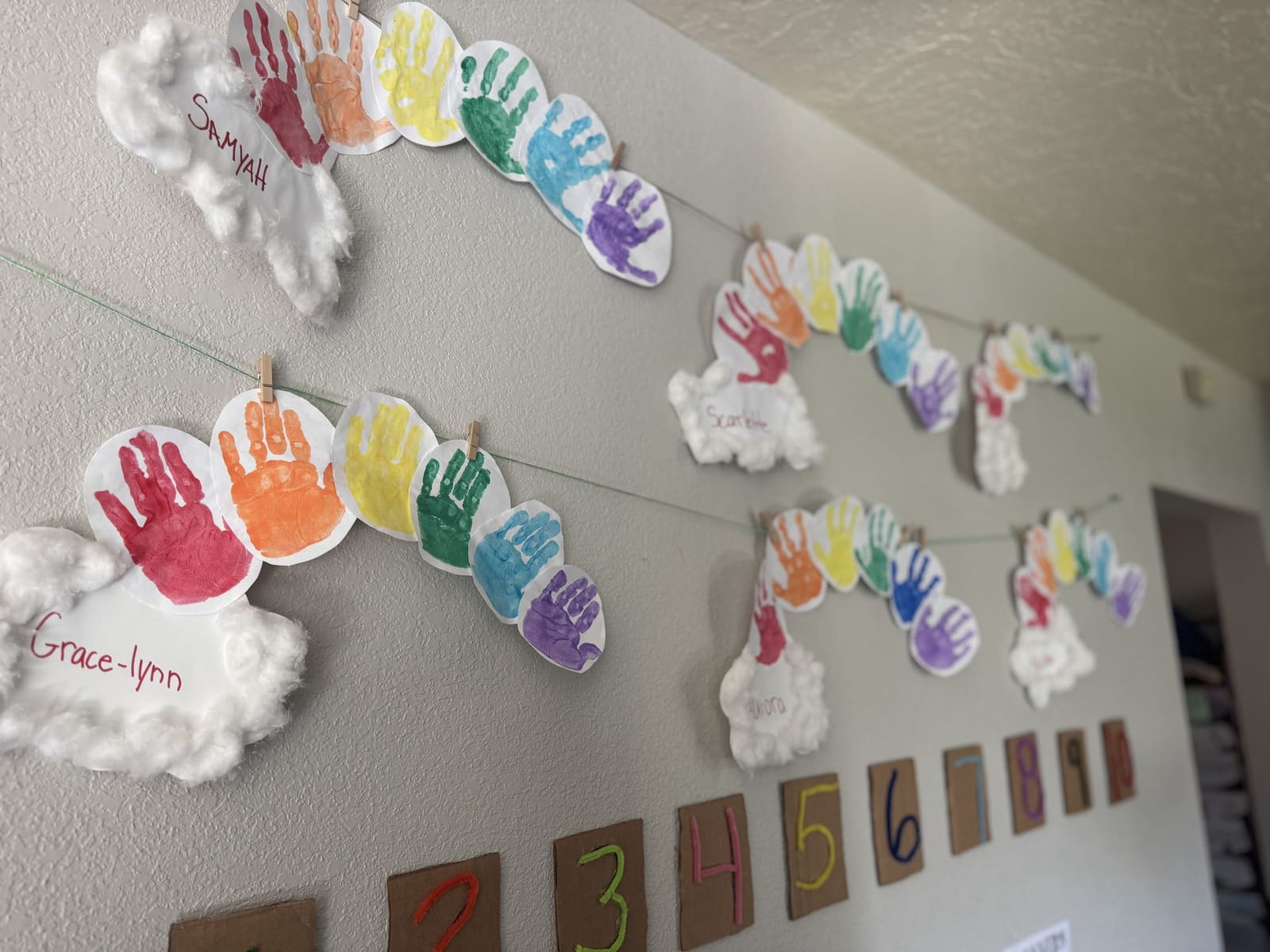 Children's handprint rainbow artwork on the classroom wall